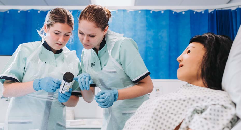 Student nurses practising urine analysis