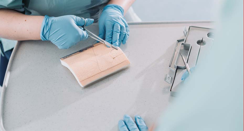 Nursing students practising wound closure techniques